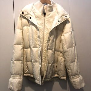 White puffy winter jacket with zipper and snap closures. Knit neck and wrist.